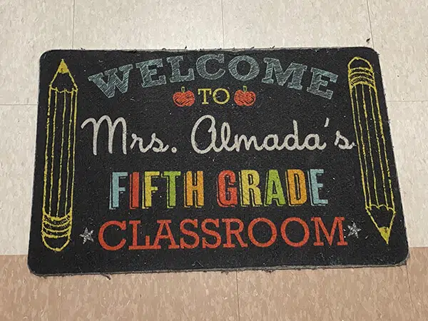 Photo of a small chalkboard that says "Mrs. Almada's Fifth Grade Classroom"