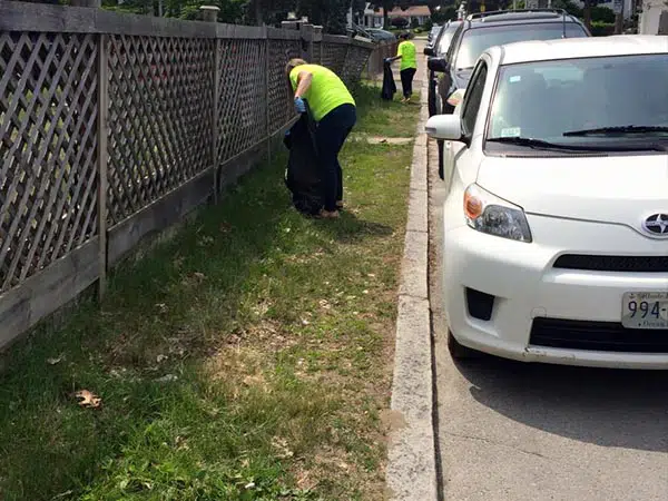 RLL team member outside on grass cleaning up