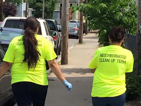 Two members of RLL's team outside cleaning up neighborhood