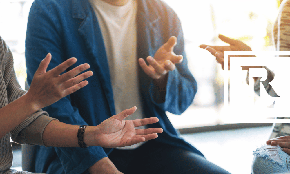 Close up of three people talking to one another, focused on their hands