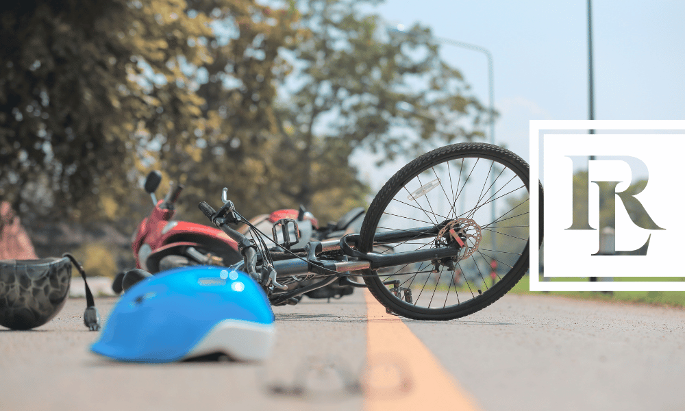 Bike fallen over on road with helmet next to it