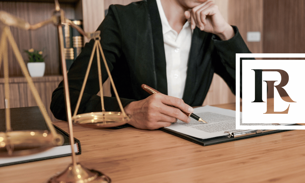 Lawyer sitting at desk with law scales in the foreground