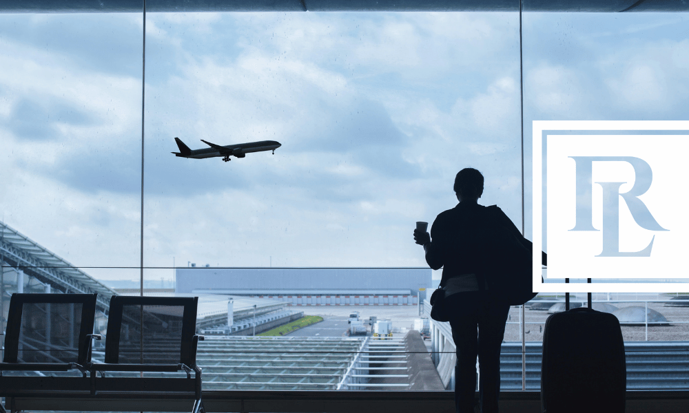 Silhouette of person in airport staring at plane taking off